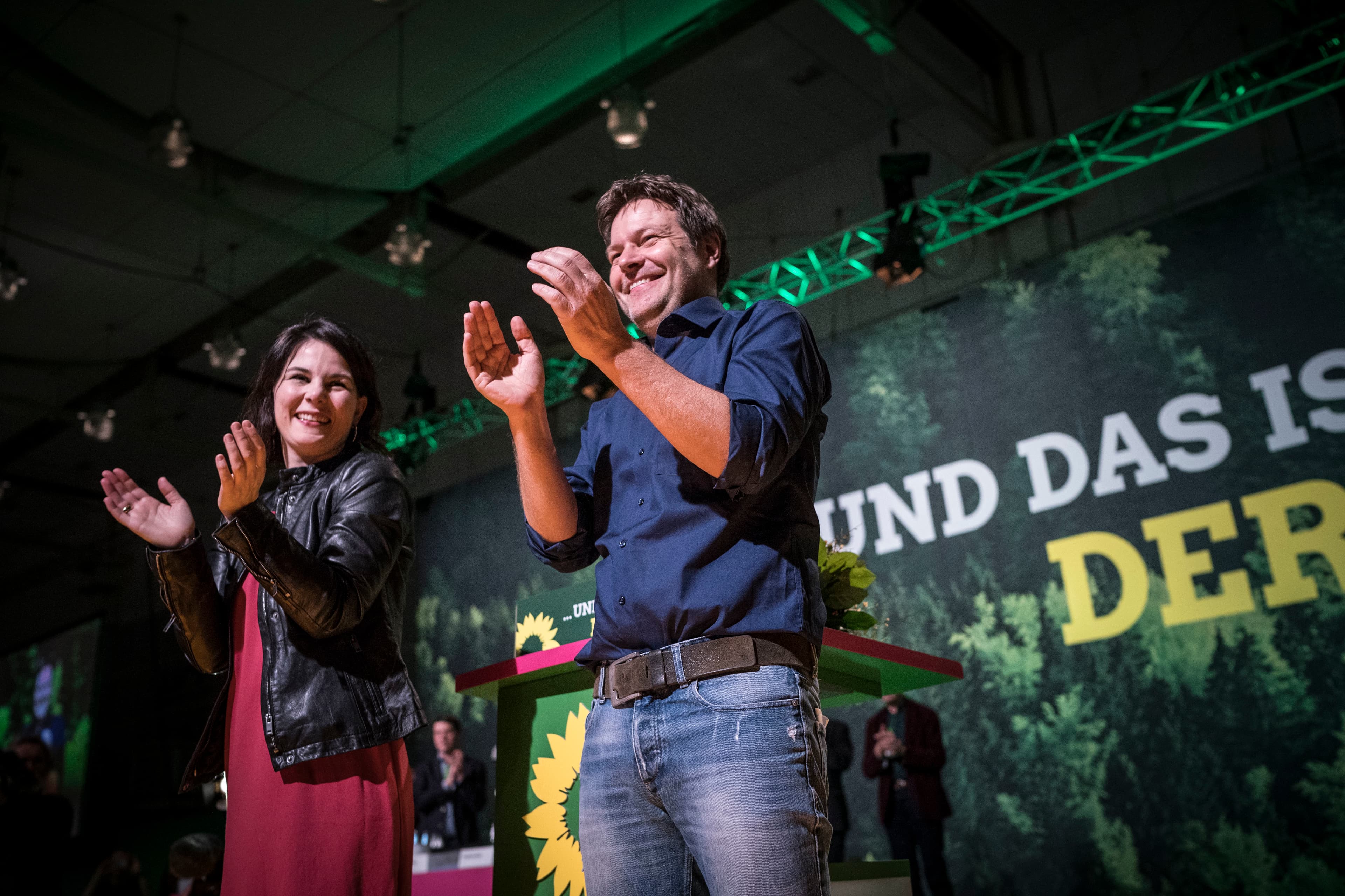 Annalena Baerbock und Robert Habeck stehen auf der Parteitagsbühne und klatschen in die Hände.