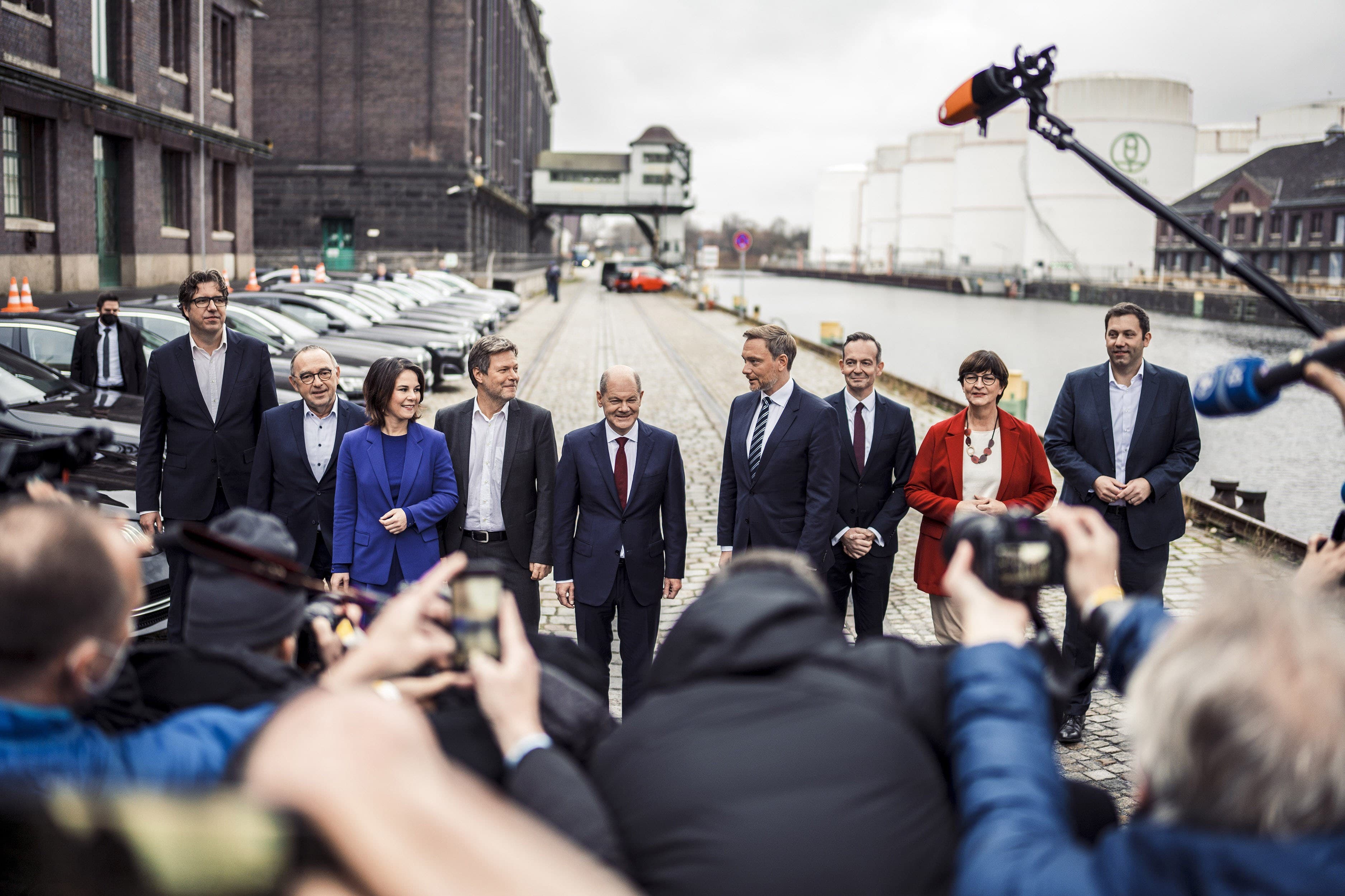 Politiker*innen von GRÜNEN, SPD und FDP stehen nebeneinander, vor ihnen viele Journalist*innen mt Kameras und Mikrofonen.