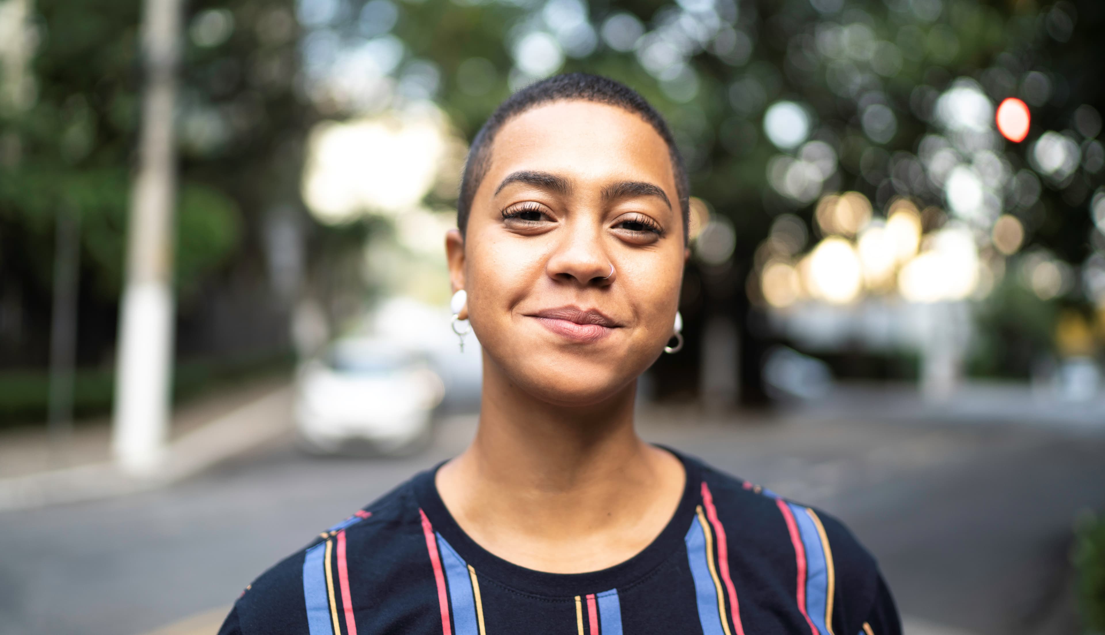 Portrait junge Frau mit kurzen Haaren und Nasenring