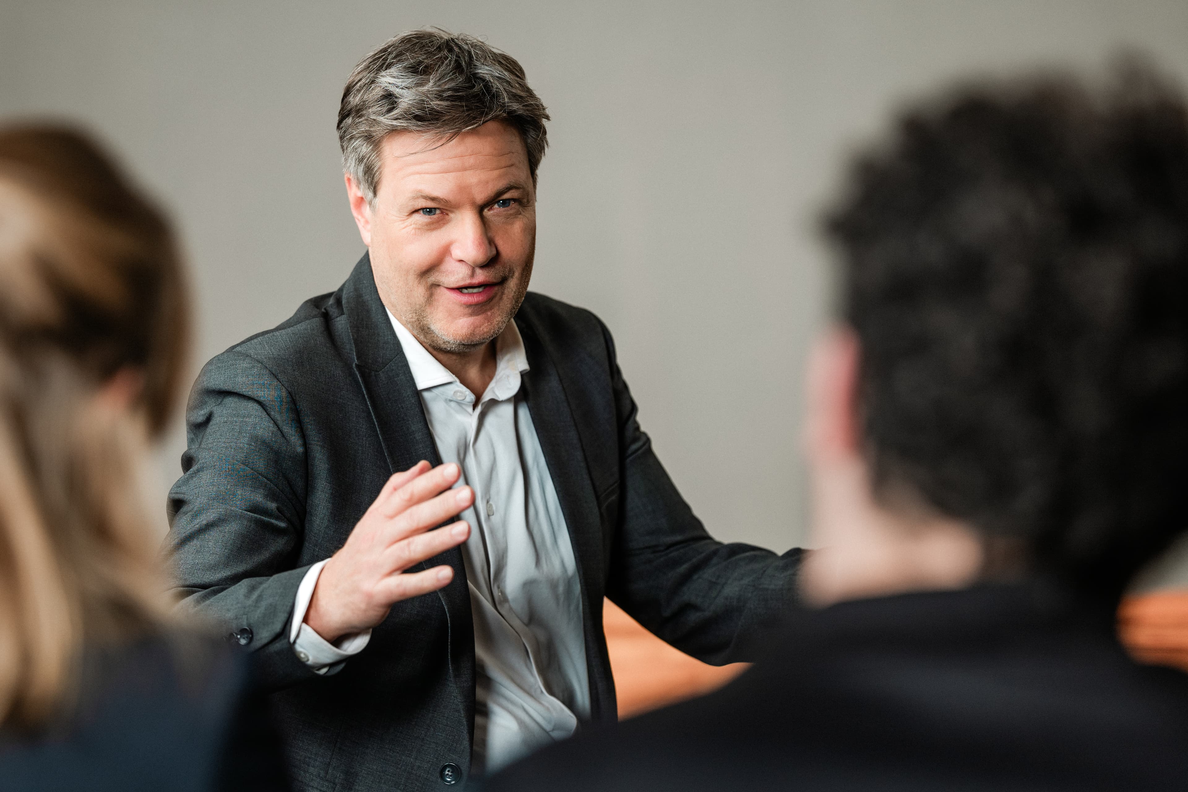 Wirtschaftsminister Robert Habeck im Gespräch mit zwei Personen.